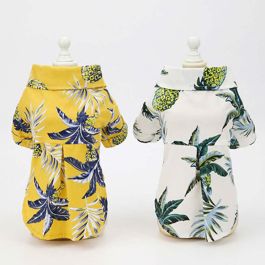 Two dog coats with tropical leaf patterns on mannequins against a white background