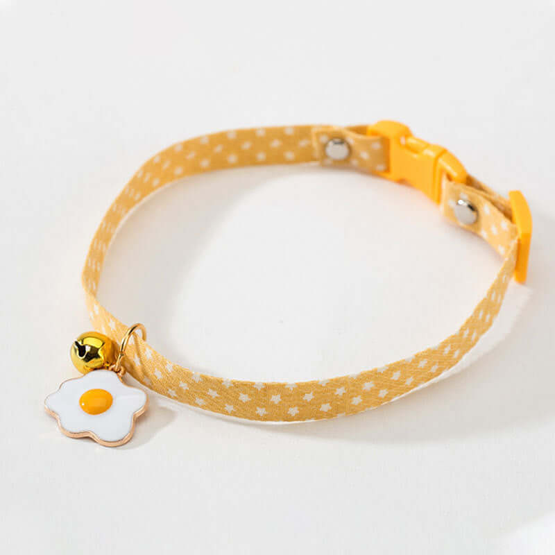 Yellow polka dot dog collar with a cute charm on a white background
