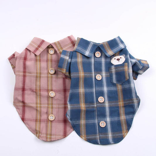 Two plaid dog shirts, one pink and one blue with a bear design, on a white background.
