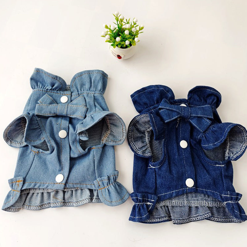 Two denim dog coats with ruffles and bows on a white background.