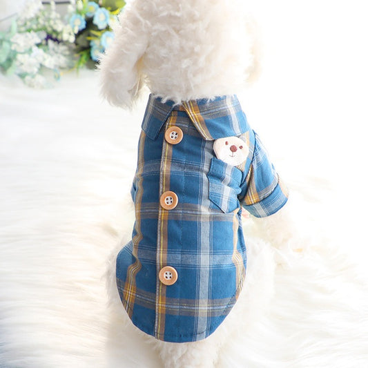 Blue plaid dog dress with buttons and a teddy bear design on a white background