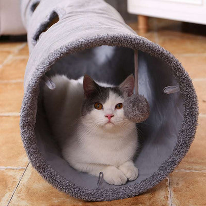 Cat sitting inside a soft grey suede tunnel toy, ideal for cozy indoor play.