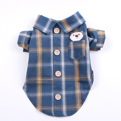Blue plaid dog shirt with a bear face patch on a white background
