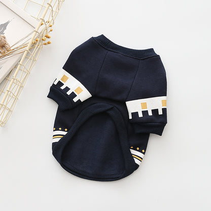 Navy blue dog sweater with white and gold accents on a light gray background