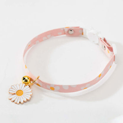 Pink polka dot choker with a white daisy charm on a light gray background