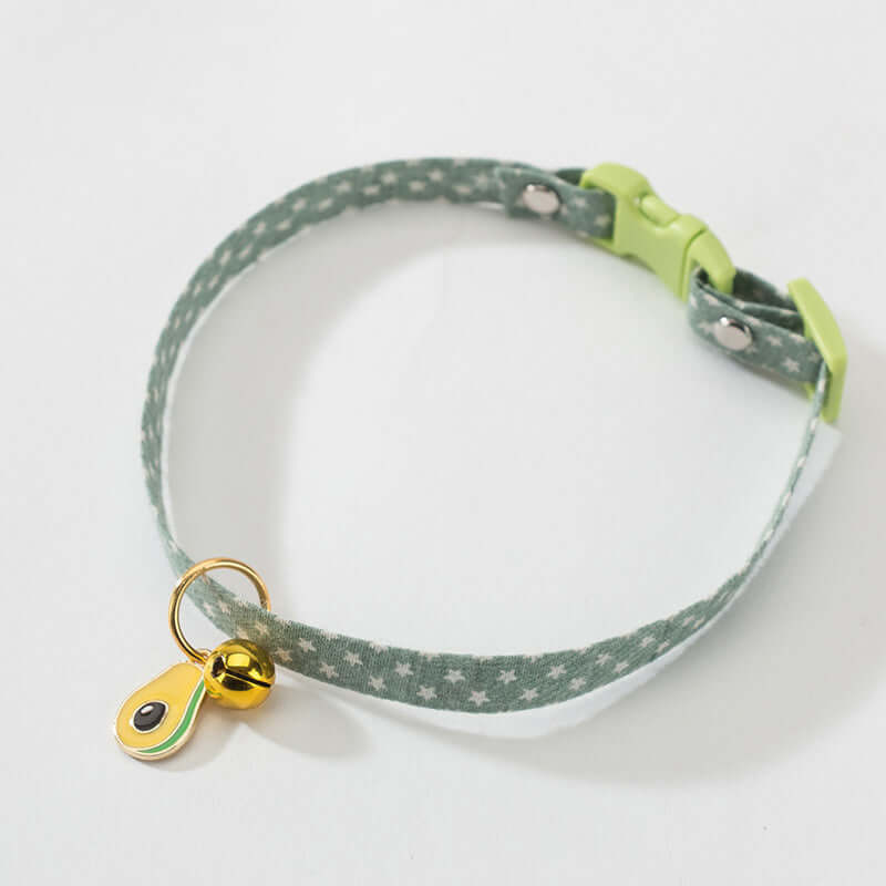 Green patterned cat collar with a gold bell on a white background