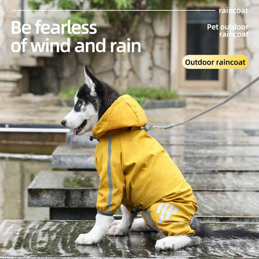 Husky dog wearing a yellow waterproof raincoat sitting near a puddle