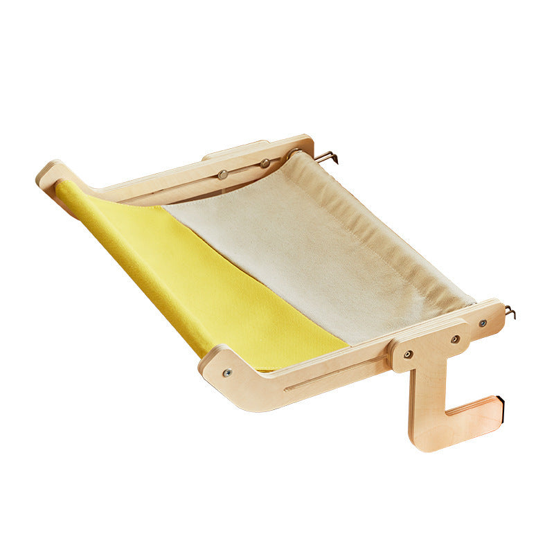 Fluffy cat relaxing on a wooden bedside hammock with yellow and white fabric.

